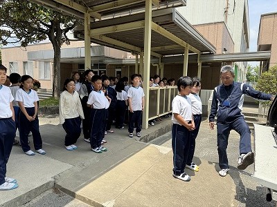 収集車の緊急停止ボタンを押して、説明しているようす