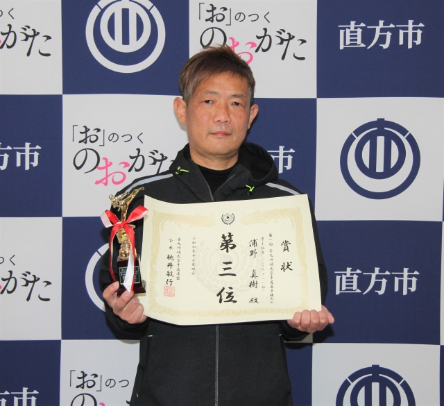 賞状とトロフィーを手にする浦野さん
