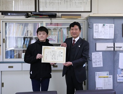 俳句大会の授賞式で最優秀句に選ばれた小学6年生と直方ロータリークラブの赤間会長の写真