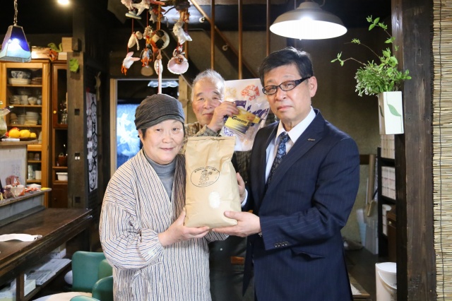 お米を贈る玉井会長（右）と池田さんご夫婦