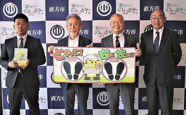 シートを手にする谷口支部長と大塚市長（左から２、3番目）