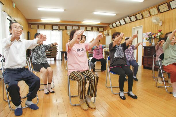 年配の方が座って体操をする写真