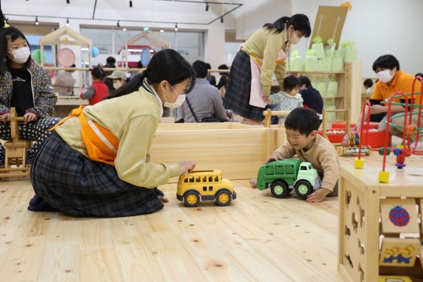 保育士が子供と遊んでいる写真