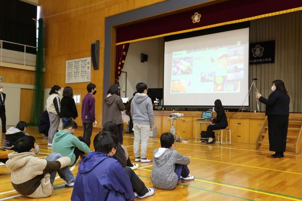 学校の体育館で子供が発表する写真