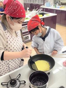 クレープ生地を焼く親子