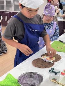 2枚重ねたクレープに具材を乗せる男の子